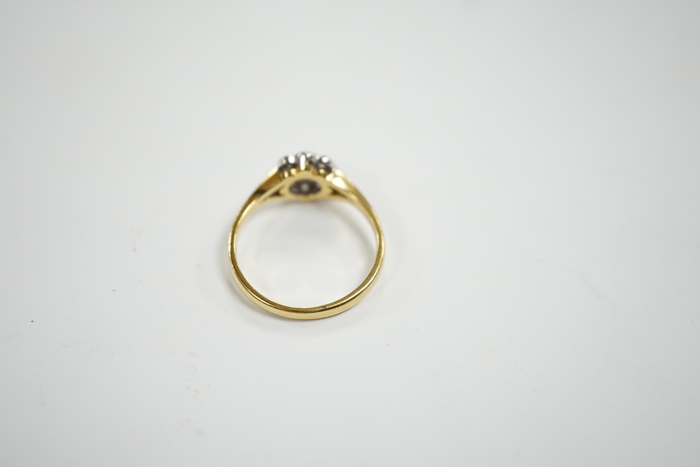 A modern 18ct gold and nine stone diamond set flower head cluster ring, size M, gross weight 3 grams.